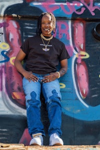 a man sitting on top of a graffiti covered wall