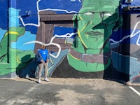 a man standing in front of a mural of a frankenstein